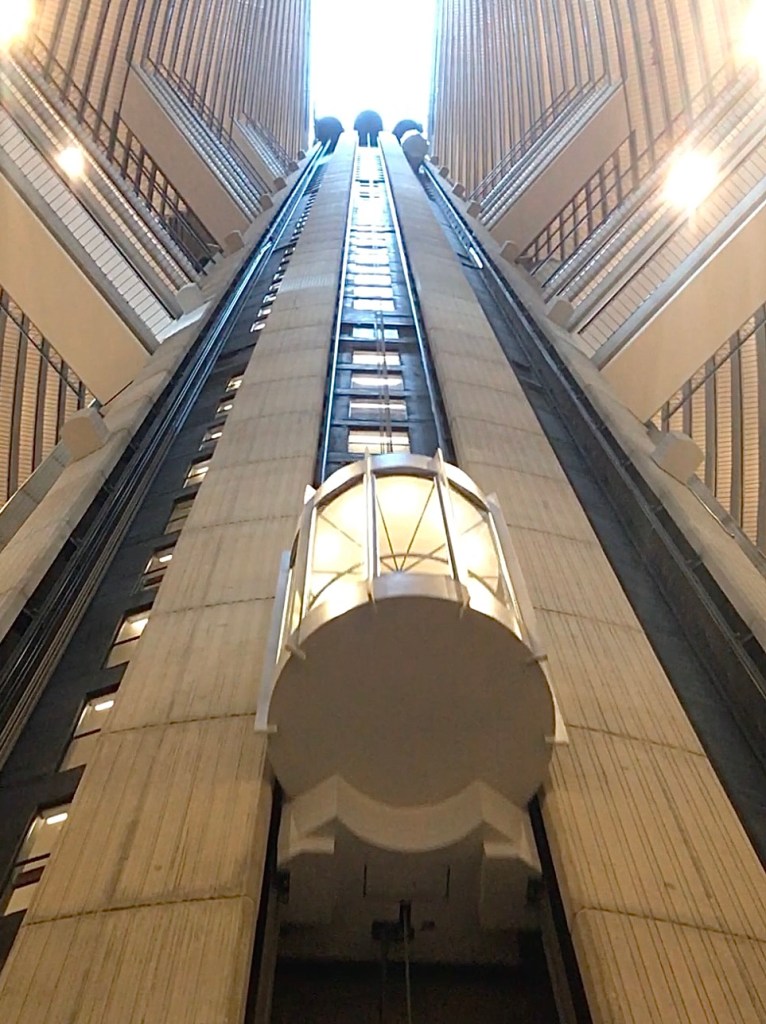 A glass elevator descending through an open atrium at Atlanta's Marriott Marquis Hotel