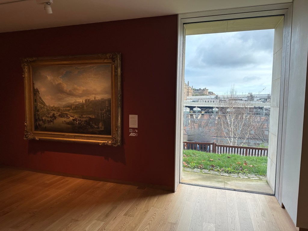 A full height window in Level 2 of the Scottish National Gallery shows an outside view towards Waverley Station.